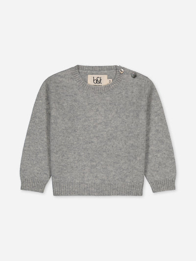 Grey baby sweater knitted in regenerated cashmere.